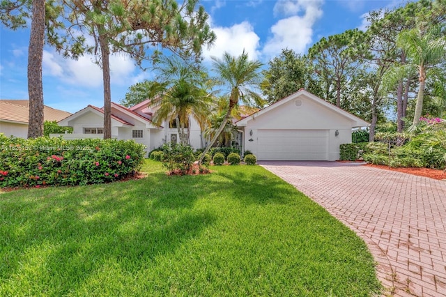 1137 SW Lighthouse Dr, Palm City, FL 34990 - view of front of home with a front yard, driveway, a garage, and stucco siding