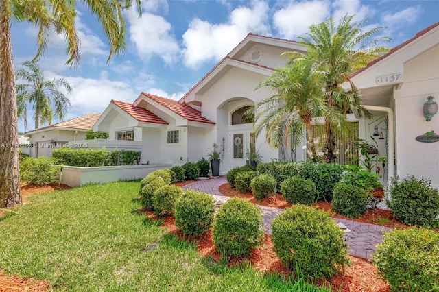 1137 SW Lighthouse Dr, Palm City, FL 34990 - view of front facade with stucco siding, a front lawn, and a tile roof