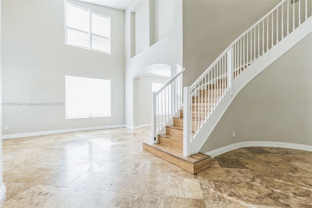 12986 SW 21st St, Miramar, FL 33027 - entrance foyer with arched walkways, stairs, stone finish flooring, and a towering ceiling