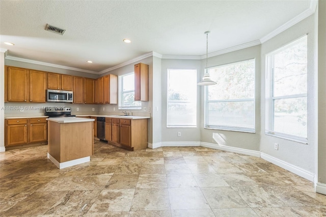 12986 SW 21st St, Miramar, FL 33027 - kitchen featuring stainless steel appliances, light countertops, crown molding, brown cabinetry, and decorative light fixtures