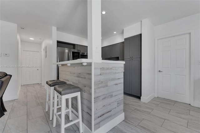 7540 Simms St, Hollywood, FL 33024 - kitchen featuring freestanding refrigerator, gray cabinetry, a kitchen bar, recessed lighting, and a center island