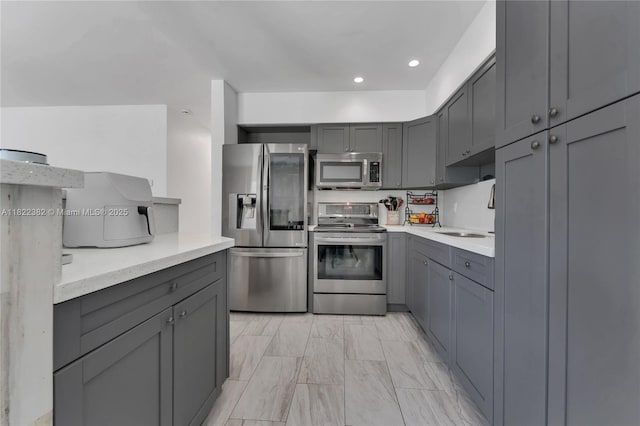 7540 Simms St, Hollywood, FL 33024 - kitchen featuring stainless steel appliances, gray cabinets, light marble finish floors, light countertops, and recessed lighting