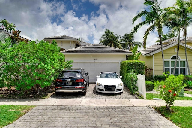 3457 NE 2nd St, Homestead, FL 33033 - view of front of house with decorative driveway, an attached garage, a tiled roof, and stucco siding