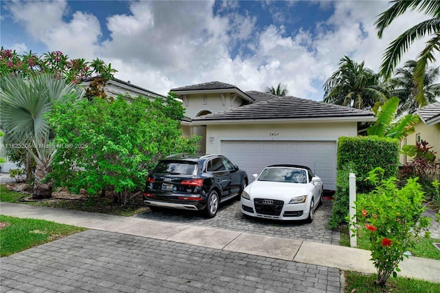 3457 NE 2nd St, Homestead, FL 33033 - view of front of property featuring decorative driveway, a tile roof, an attached garage, and stucco siding