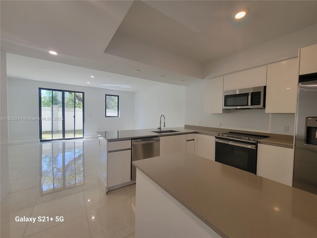 4117 N Oak Pl, Dania Beach, FL 33314 - kitchen with appliances with stainless steel finishes, a peninsula, modern cabinets, recessed lighting, and white cabinets