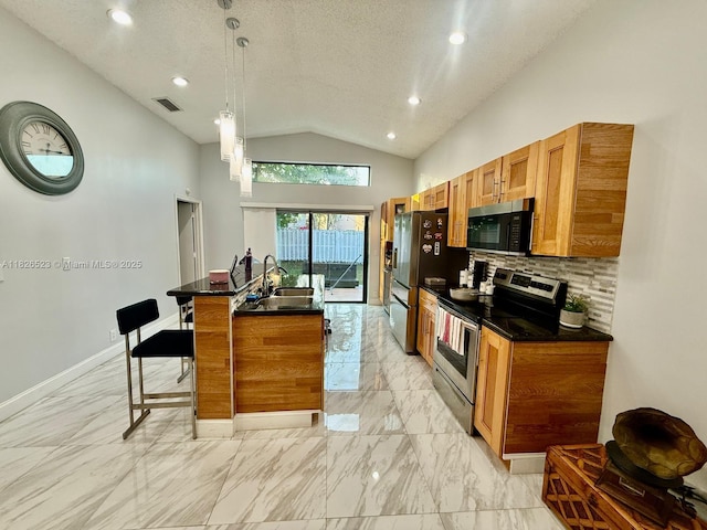 17673 SW 19th St, Miramar, FL 33029 - kitchen featuring stainless steel appliances, dark countertops, lofted ceiling, brown cabinets, and light marble finish flooring