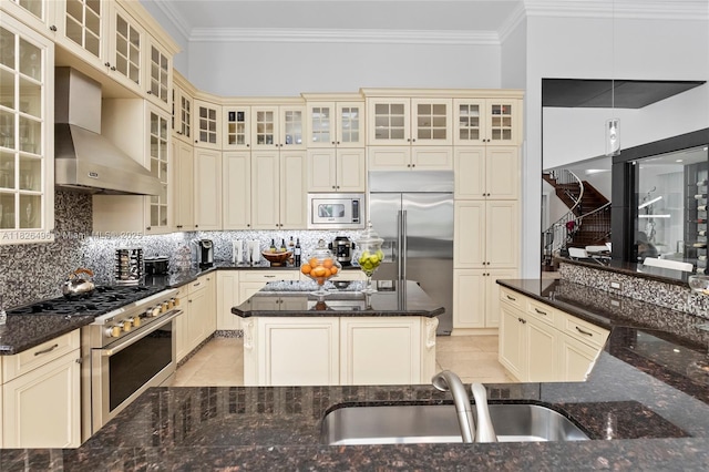 17866 Lake Azure Way, Boca Raton, FL 33496 - kitchen featuring cream cabinets, built in appliances, wall chimney exhaust hood, light tile patterned floors, and crown molding
