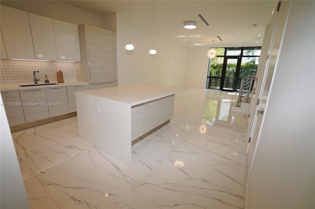 3313 Percival Ave Unit 3313, Miami, FL 33133 - kitchen featuring modern cabinets, light marble finish flooring, a center island, light countertops, and floor to ceiling windows
