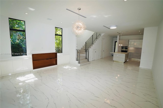 3313 Percival Ave Unit 3313, Miami, FL 33133 - unfurnished living room with stairway, light marble finish flooring, and a chandelier