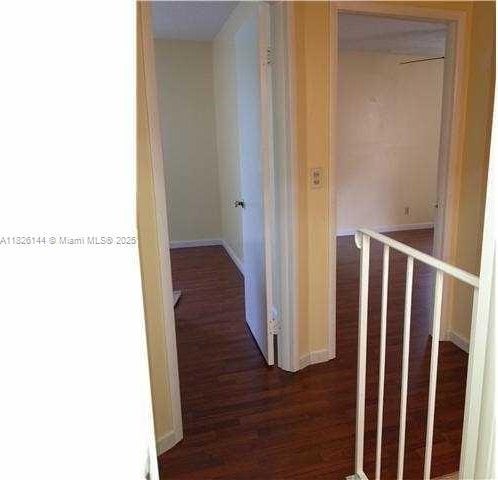 8917 NW 28th Dr Unit C-51, Coral Springs, FL 33065 - hallway featuring dark wood finished floors and baseboards