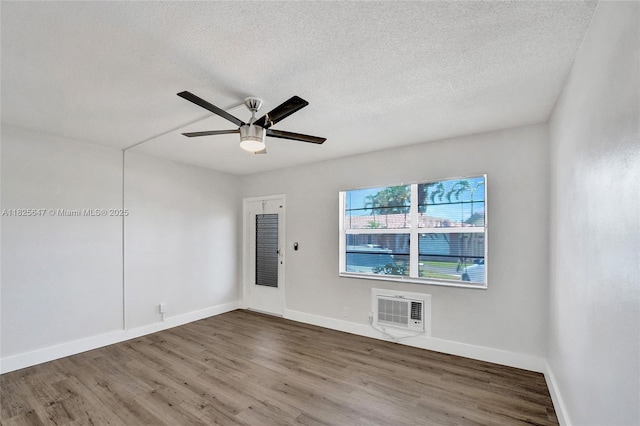 2106 NE 56th Ct Unit 108, Fort Lauderdale, FL 33308 - spare room with wood finished floors, ceiling fan, an AC wall unit, and a textured ceiling