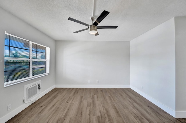 2106 NE 56th Ct Unit 108, Fort Lauderdale, FL 33308 - unfurnished room featuring wood finished floors, a wall mounted AC, ceiling fan, and a textured ceiling