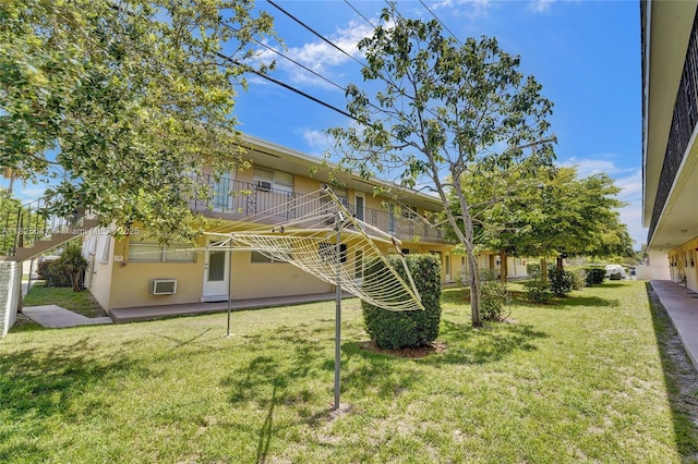 2106 NE 56th Ct Unit 108, Fort Lauderdale, FL 33308 - rear view of house featuring a lawn, a wall mounted air conditioner, and a balcony