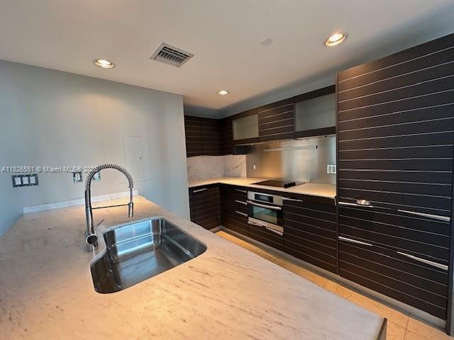 200 Biscayne Boulevard Way Unit 701, Miami, FL 33131 - kitchen featuring oven, modern cabinets, light countertops, recessed lighting, and black electric cooktop