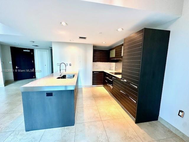 200 Biscayne Boulevard Way Unit 701, Miami, FL 33131 - kitchen with light countertops, modern cabinets, black electric stovetop, light tile patterned flooring, and recessed lighting