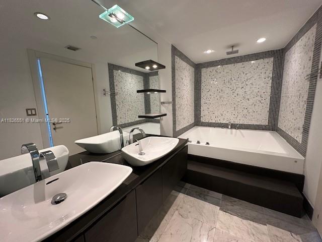 200 Biscayne Boulevard Way Unit 701, Miami, FL 33131 - bathroom with a bath, double vanity, a tile shower, marble look tiles, and recessed lighting