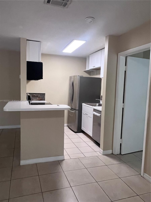 15 Crossings Cir Unit F, Boynton Beach, FL 33435 - kitchen with appliances with stainless steel finishes, white cabinetry, light tile patterned flooring, and a peninsula