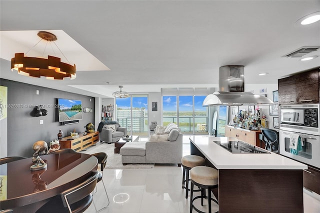 7930 E Dr Unit 1806, North Bay Village, FL 33141 - kitchen with stainless steel appliances, a kitchen island, a kitchen breakfast bar, light countertops, and light tile patterned floors