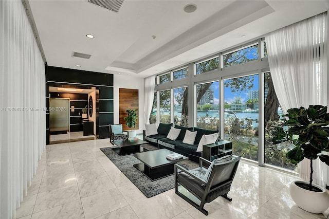 7930 E Dr Unit 1806, North Bay Village, FL 33141 - living room featuring a raised ceiling, a water view, light marble finish floors, plenty of natural light, and recessed lighting