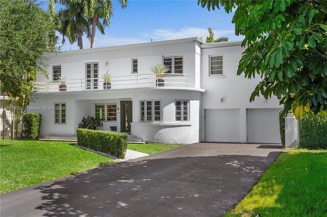600 NE 55th Ter, Miami, FL 33137 - art deco inspired home with a balcony, stucco siding, driveway, a garage, and a front lawn