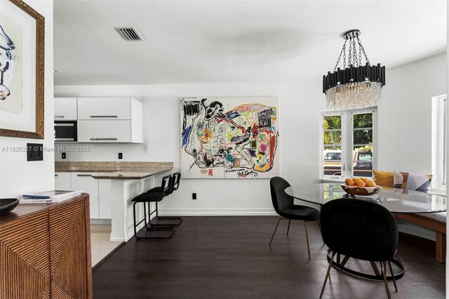 600 NE 55th Ter, Miami, FL 33137 - dining area featuring wood finished floors and a chandelier