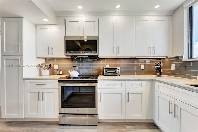 200 Ocean Trail Way Unit 701, Jupiter, FL 33477 - kitchen with stainless steel appliances, white cabinets, light wood-style floors, tasteful backsplash, and recessed lighting