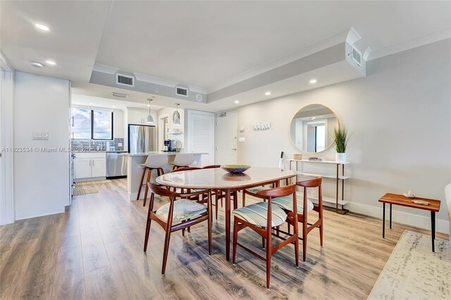200 Ocean Trail Way Unit 701, Jupiter, FL 33477 - dining space featuring light wood finished floors, ornamental molding, recessed lighting, and a tray ceiling