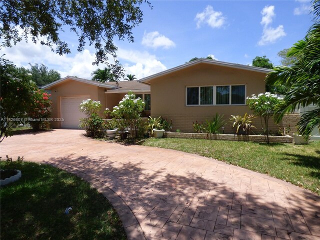 5501 Johnson St, Hollywood, FL 33021 - single story home featuring a garage, stucco siding, decorative driveway, and brick siding