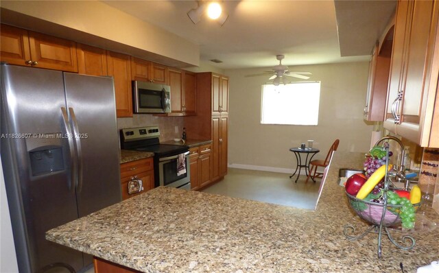 5501 Johnson St, Hollywood, FL 33021 - kitchen with appliances with stainless steel finishes, light stone countertops, brown cabinetry, decorative backsplash, and ceiling fan