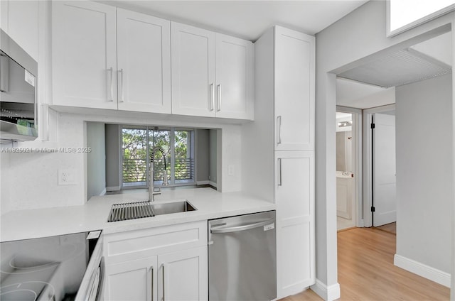 9311 Orange Grove Dr Unit 409, Davie, FL 33324 - kitchen featuring stainless steel appliances, light countertops, white cabinetry, and light wood finished floors