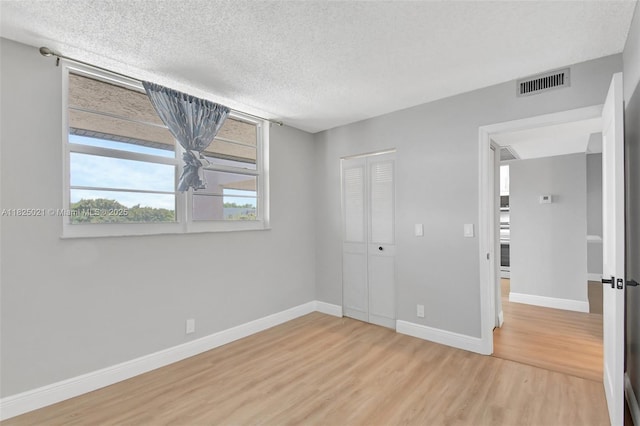 9311 Orange Grove Dr Unit 409, Davie, FL 33324 - unfurnished bedroom featuring light wood-type flooring, a textured ceiling, and a closet