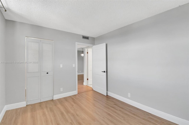 9311 Orange Grove Dr Unit 409, Davie, FL 33324 - unfurnished bedroom featuring light wood finished floors, a textured ceiling, and a closet