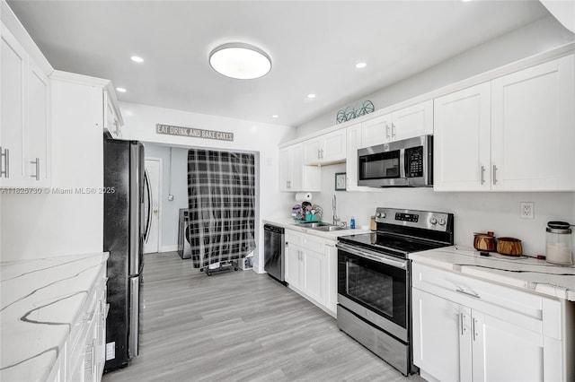 17415 NW 27th Ct, Miami Gardens, FL 33056 - kitchen featuring appliances with stainless steel finishes, white cabinets, recessed lighting, light stone counters, and light wood finished floors