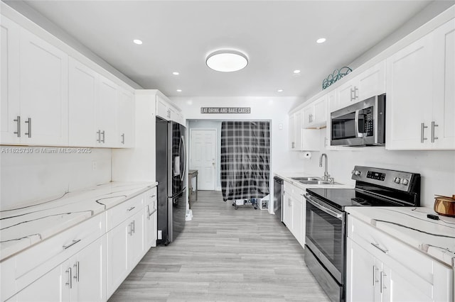 17415 NW 27th Ct, Miami Gardens, FL 33056 - kitchen with stainless steel appliances, white cabinets, light wood-type flooring, recessed lighting, and light stone countertops