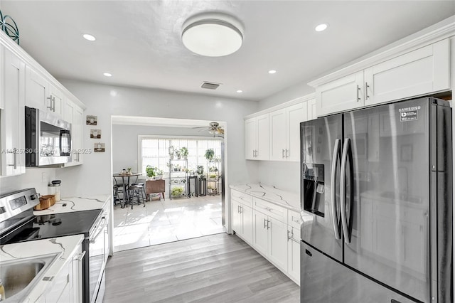 17415 NW 27th Ct, Miami Gardens, FL 33056 - kitchen featuring stainless steel appliances, white cabinets, light stone counters, a ceiling fan, and recessed lighting
