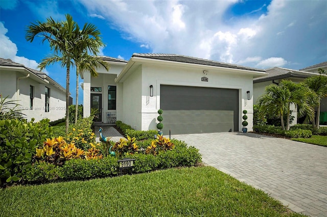 9190 SW Esule Way, Port St Lucie, FL 34987 - view of front of property featuring an attached garage, stucco siding, and decorative driveway