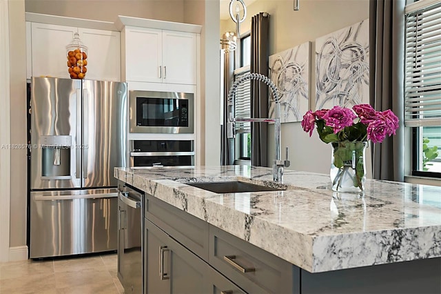 9190 SW Esule Way, Port St Lucie, FL 34987 - kitchen featuring appliances with stainless steel finishes, light stone counters, white cabinets, and light tile patterned floors
