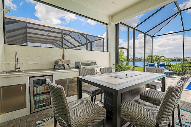9190 SW Esule Way, Port St Lucie, FL 34987 - view of patio with exterior kitchen, a lanai, wine cooler, and a water view