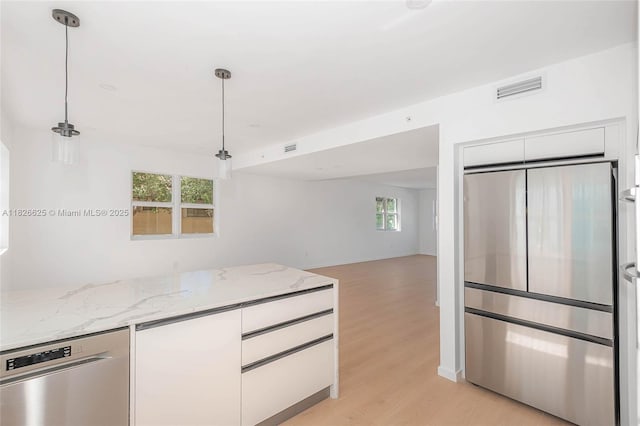 824 SE 12th Ct Unit 1, Fort Lauderdale, FL 33316 - kitchen with stainless steel appliances, light wood finished floors, white cabinetry, and healthy amount of natural light