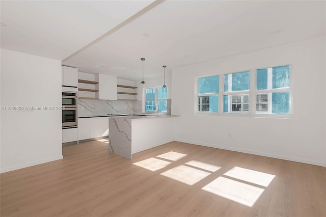 824 SE 12th Ct Unit 1, Fort Lauderdale, FL 33316 - kitchen with open shelves, white cabinetry, light wood-type flooring, and decorative light fixtures