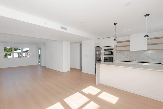 824 SE 12th Ct Unit 1, Fort Lauderdale, FL 33316 - kitchen with stainless steel double oven, decorative backsplash, light wood-type flooring, and open shelves