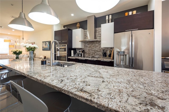 10260 NW 63rd Ter Unit 208, Doral, FL 33178 - kitchen featuring stainless steel appliances, wall chimney exhaust hood, tasteful backsplash, a breakfast bar area, and light stone countertops