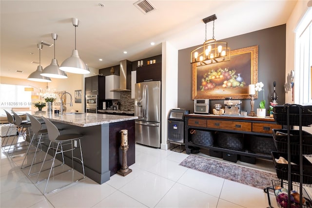 10260 NW 63rd Ter Unit 208, Doral, FL 33178 - kitchen with appliances with stainless steel finishes, a chandelier, wall chimney range hood, a breakfast bar area, and recessed lighting