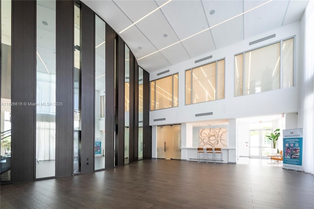 10260 NW 63rd Ter Unit 208, Doral, FL 33178 - unfurnished living room featuring a towering ceiling and wood finished floors