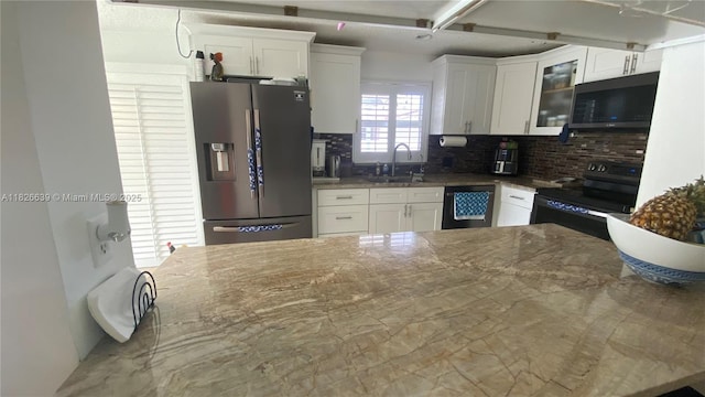 7809 NW 40th Ct, Coral Springs, FL 33065 - kitchen with black appliances, tasteful backsplash, white cabinetry, and glass insert cabinets