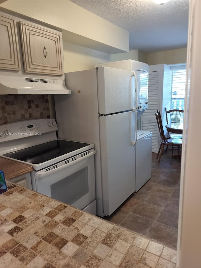 13791 Flora Pl Unit B, Delray Beach, FL 33484 - kitchen featuring electric range, under cabinet range hood, tile counters, washer / dryer, and a textured ceiling
