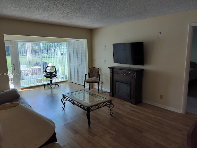 13791 Flora Pl Unit B, Delray Beach, FL 33484 - living area with a glass covered fireplace, wood finished floors, and a textured ceiling