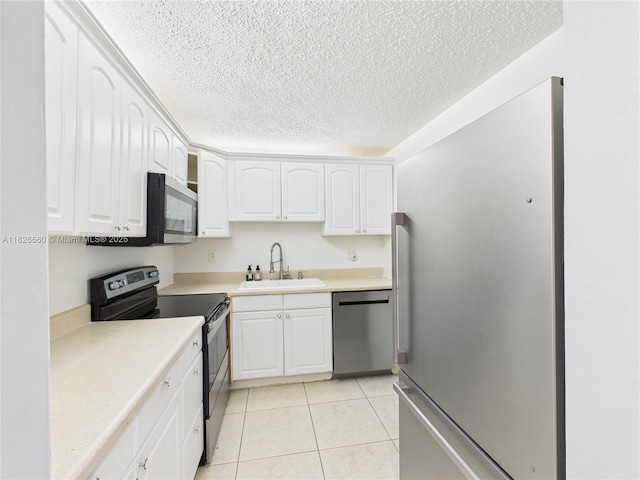 4113 NW 88th Ave Unit 105, Coral Springs, FL 33065 - kitchen featuring stainless steel appliances, white cabinets, light countertops, a textured ceiling, and light tile patterned floors