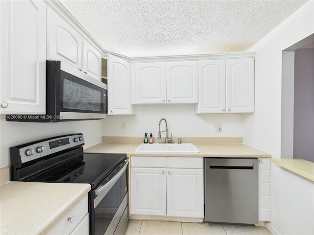 4113 NW 88th Ave Unit 105, Coral Springs, FL 33065 - kitchen featuring appliances with stainless steel finishes, white cabinetry, light tile patterned flooring, light countertops, and a textured ceiling