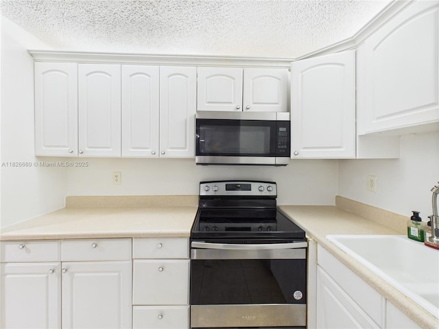 4113 NW 88th Ave Unit 105, Coral Springs, FL 33065 - kitchen with appliances with stainless steel finishes, a textured ceiling, white cabinets, and light countertops